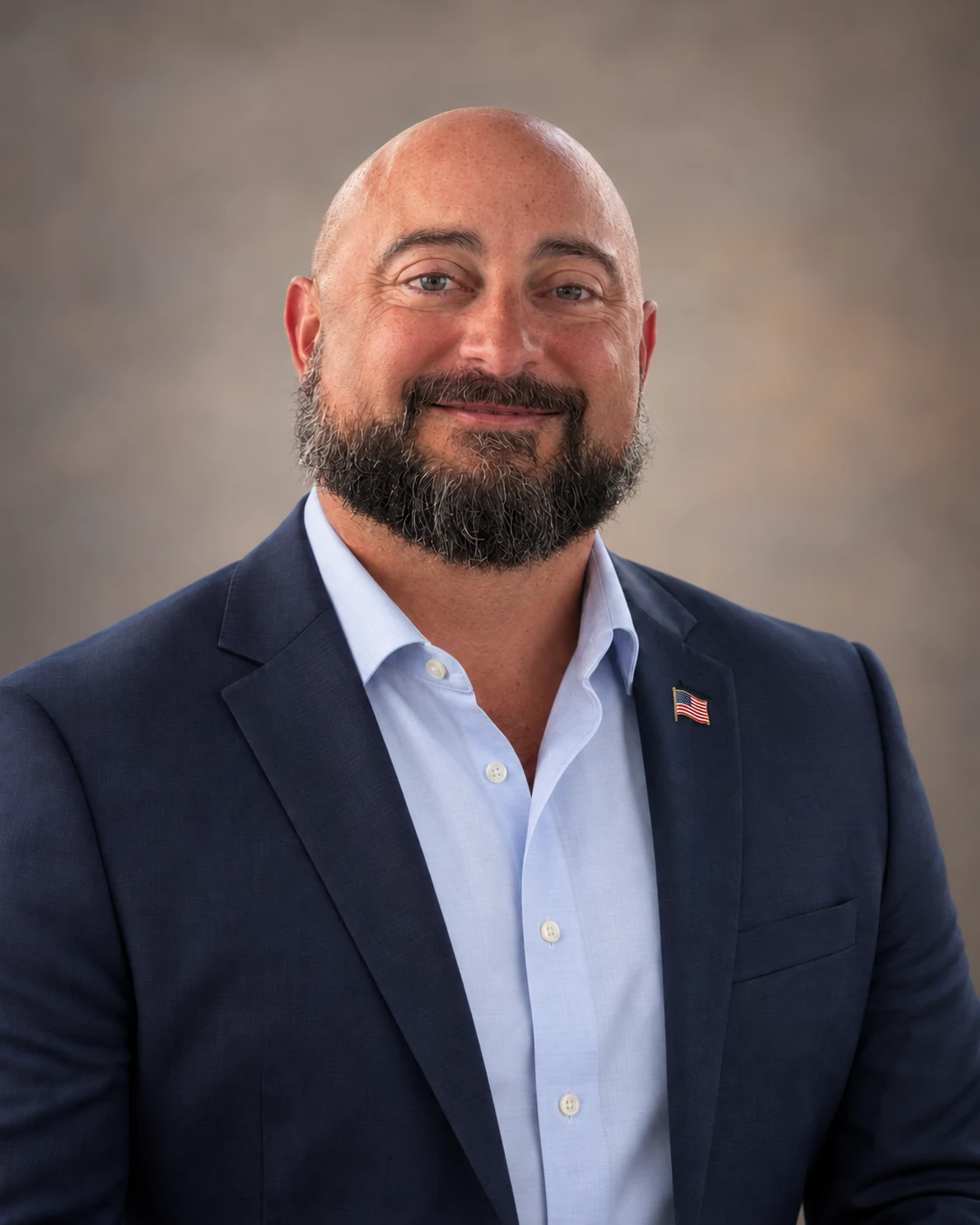 Eric Vidinha in a navy jacket with an American flag lapel pin